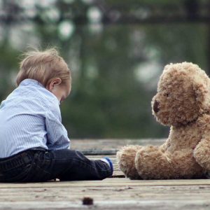 Young Boy Sitting With Large Teddy Bear