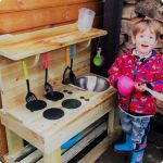 Young Boy Playing With A Mud Kitchen