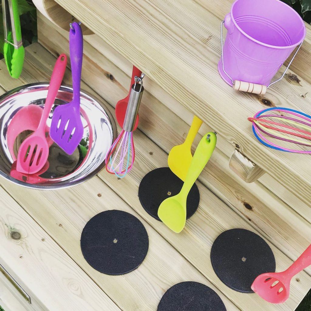 Close Up On Mud Kitchen With Plastic Utensils
